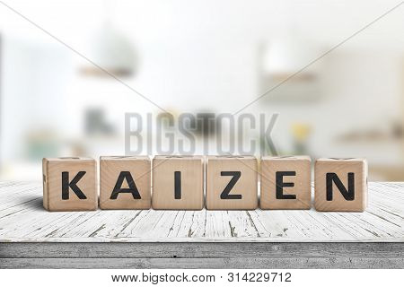 Kaizen Improvement Sign Made Of Blocks On A Wooden Desk In A Bright Room