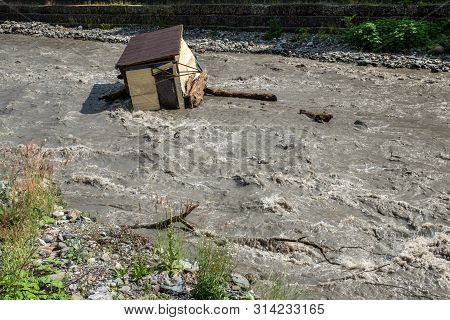 A Small House Destroyed The Mudflow In The Mountains. A Small House Was Washed Away By A Flooded Mou