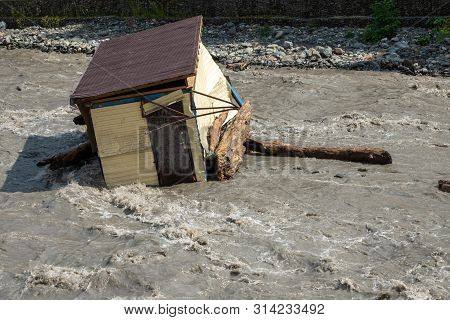A Small House Destroyed The Mudflow In The Mountains. A Small House Was Washed Away By A Flooded Mou