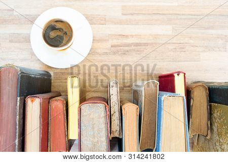 Books Row On Wooden Table With White Cup Of Coffee, Top View Flat Lay. Reading, Learning, Literature