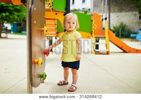 Adorable Toddler Girl Having Fun On Playground. Outdoor Activities For Kids