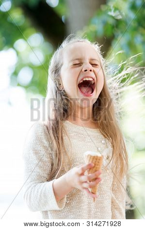 Ice Cream Makes Her Fall Into Euphoria. Cute Little Girl Eating Ice Cream On Summer Day. Small Child