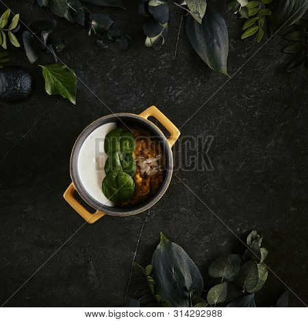 Exquisite Serving Restaurant Dish of Cooked Quinoa with Carrot Celeriac Cream and Ricotta Cheese Top View. Italian Cuisine with Kinoa, Kinwa or Kinuwa Seeds on Black Marble Table
