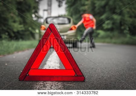 Red Warning Triangle And Broken Car On Road - Car Breakdown Concept