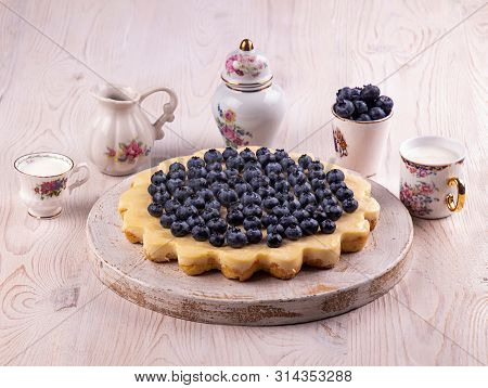 Homemade Cheesecake Decorated With Blueberry Over On White Wooden Background. Top View