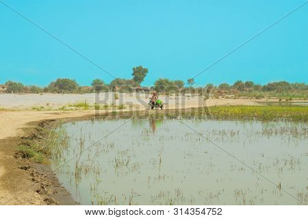 Punjab,pakistan-june 23,2019:an Unidentified Man Driving A Moto Rickshaw In A Flood Affected Area,bl