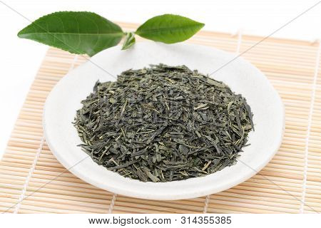 Dried Tea Leaves With Green Tea Leaves On Bamboo Background