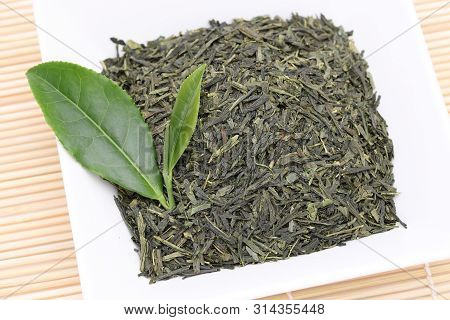 Dried Tea Leaves With Green Tea Leaves On Bamboo Background