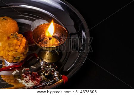 Indian Festival - Rice Grains, Kumkum, Sweets And Diya On Plate With An Elegant Rakhi. Brother And S