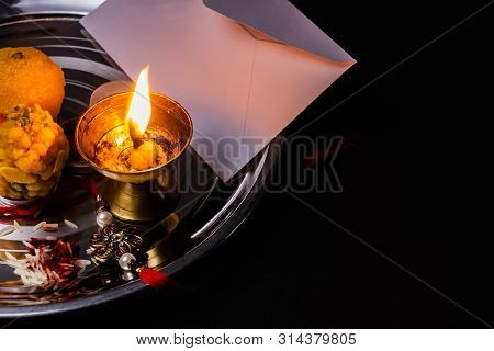 Indian Festival Concept- Elegant Rakhi With Rice Grains, Kumkum, Sweets, Diya And White Envelope On 
