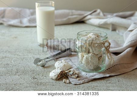 Traditional Beze Or Meringues With Nuts In A Glass Jar On Concrete Background. Copy Space. A Glass O