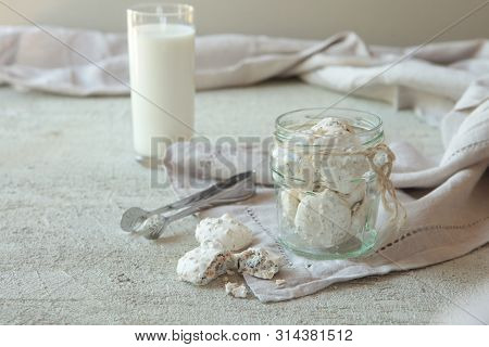 Traditional Beze Or Meringues With Nuts In A Glass Jar On Concrete Background. Copy Space. A Glass O