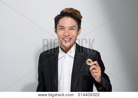 Happy Man In A Balck Siut Holding A Bitcoin In His Hand