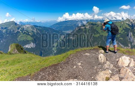 Photographer Traveler Makes A Photo Of The Alpine Valley On A Mannlichen Mountain Viewpoint, Bernese