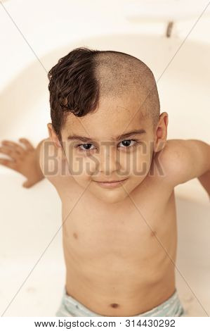 Six-year Boy At Haircutting At Home. Father Cut Half Of The Son's Hair Off At The Bathroom
