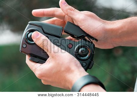 Close Up Of Man Folding Drone Quadcopter Joystick Controller At Park.