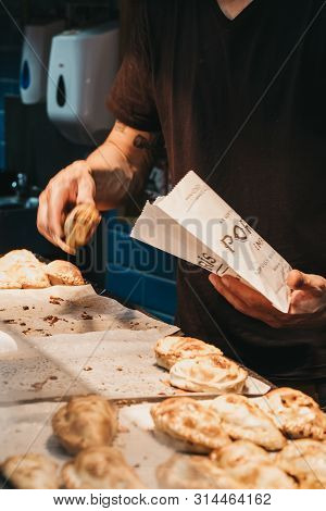 London, Uk - July 23, 2019: Man Selling Empanadas At Porteno Market Stall Inside Borough Market, One