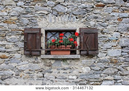 Window With Red Geranium On A Stone House