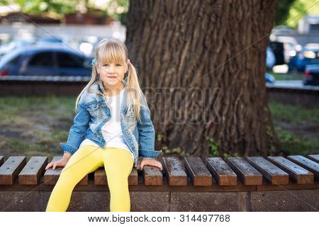 Adorable Blond Caucasian Preschooler Fashionista Girl Wearing Jeans And Bright Yellow Leggins Sittin