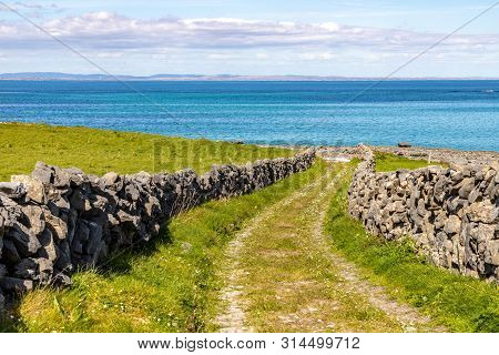 Farm Road And Field With  Galway Bay In Background In Inishmore
