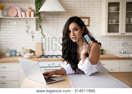Sexy Girl In Black Underwear And White Shirt Using Laptop, Holding Credit Card And Looking At Camera