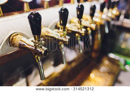 Close Up Of Beer Taps In Row. Metallic Equipment For Bars And Mini Brewerys. Concept Of Modern Equip