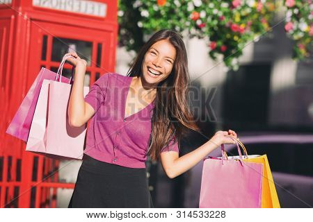 Shopping bags Asian woman in London shops spending money - Europe travel tourist chinese girl having fun enjoying summer holidays.