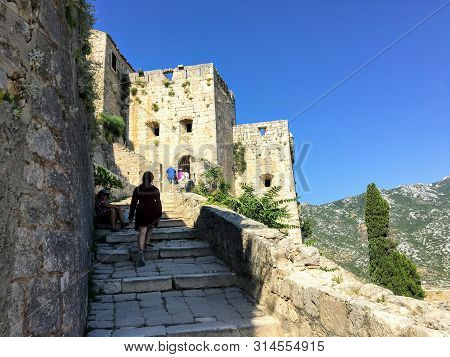 Klis Fortress, Klis, Croatia - July 6th, 2019: A Young Female Tourist And Her Family Walking Around 
