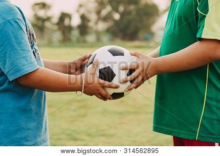 Action Sport Outdoors Of A Group Of Kids Having Fun Playing Soccer Football For Exercise In Communit