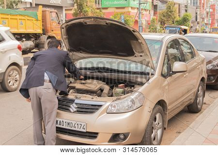 Bengaluru, India June 27,2019 : Businessman Trying To Insepct His Broken Car On Road Side At Bengalu