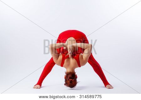 Beautiful Slim Woman In Sports Overalls  Doing Yoga, Standing In An Asana Balancing Pose - Prasarita