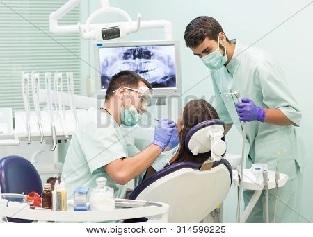 Doctor Dentist With An Assistant Work In A Dental Clinic
