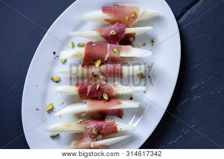 Still life of jamon serrano with yellow melon