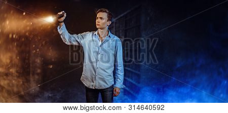 A portrait of a young goodlooking guy with a torch. Men casual fashion, fear.