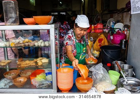 Ipoh, Malaysia - December 11: Woman Serves Up Noodles For Clients On A Food Court Of Ipoh On Decembe