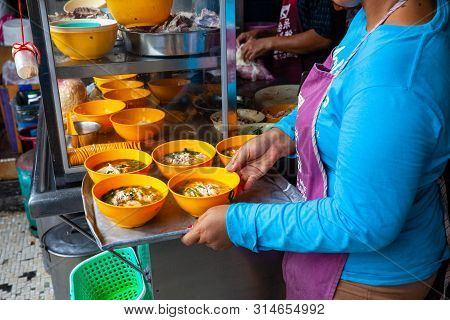 Ipoh, Malaysia - December 11: Woman Serves Up Chicken Soup For Clients On A Food Court Of Ipoh On De