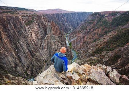 Tourist on the granite cliffs of the Black Canyon of the Gunnison, Colorado, USA