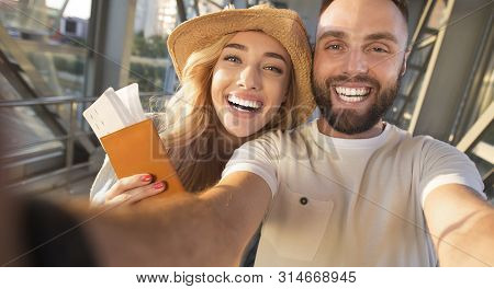Ready For Vacation. Happy Couple Making Selfie At Airport Terminal, Woman Holding Passports