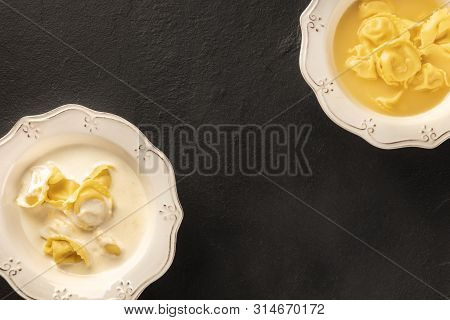 Tortellini Served With Broth And Cream Sauce, Italian Food On A Black Background With A Place For Te
