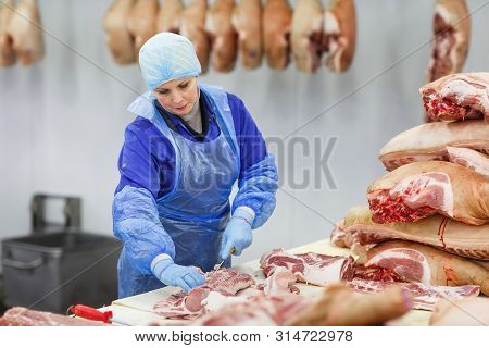 Cutting Meat In Slaughterhouse. Butcher Cutting Pork At The Meat Manufacturing.