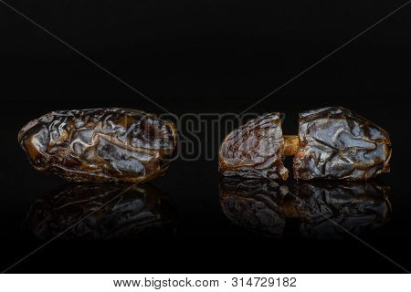 Group Of One Whole Two Halves Of Dried Brown Date Medjool Isolated On Black Glass