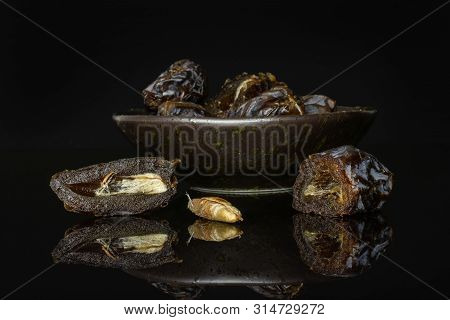 Group Of Lot Of Whole Two Halves One Piece Of Dried Brown Date Medjool On Grey Ceramic Plate Isolate