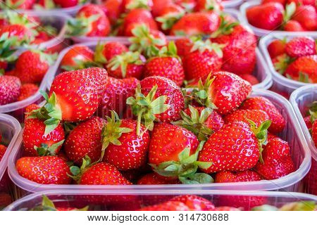 Fresh Ripe Strawberries In Plastic Boxes On Market