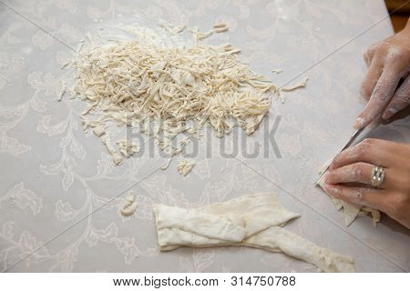 Cutting Long Dough Stripe For Cooking Pasta. Homemade Food Preparation Concept. Closeup Of Process O