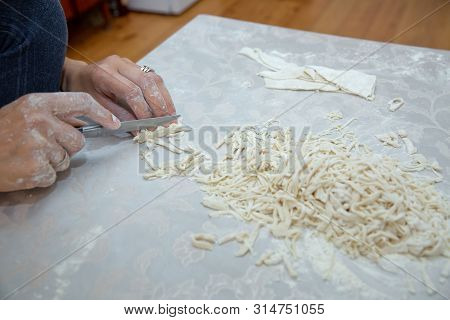 Cutting Long Dough Stripe For Cooking Pasta. Homemade Food Preparation Concept. Closeup Of Process O