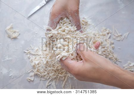 Cutting Long Dough Stripe For Cooking Pasta. Homemade Food Preparation Concept. Closeup Of Process O