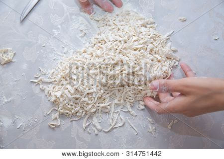 Cutting Long Dough Stripe For Cooking Pasta. Homemade Food Preparation Concept. Closeup Of Process O