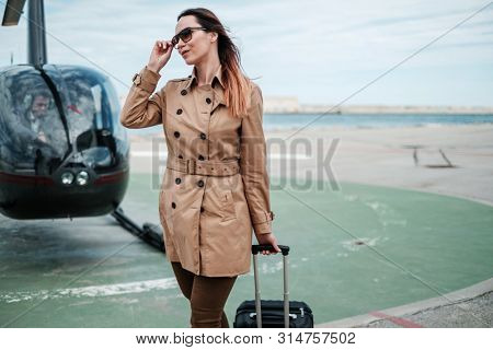 Business woman near private a helicopter