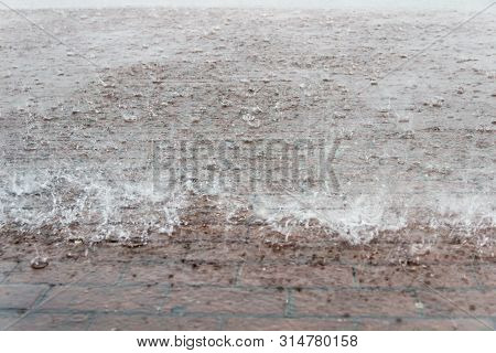 Heavy Rain In The City. Town Square. Close Up Sidewalk With Brown Rectangle Tiles Under Water With B
