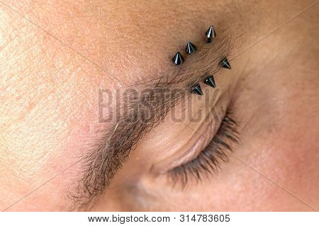 Man With Pierced Eyebrow. Three Small Black Piercings